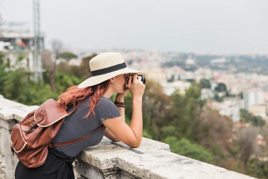 female-tourist-with-camera-balcony_23-2147981890